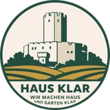 Logo Hausklar: Burgturm über Feldern